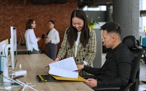 Colleagues reviewing documents at an office desk