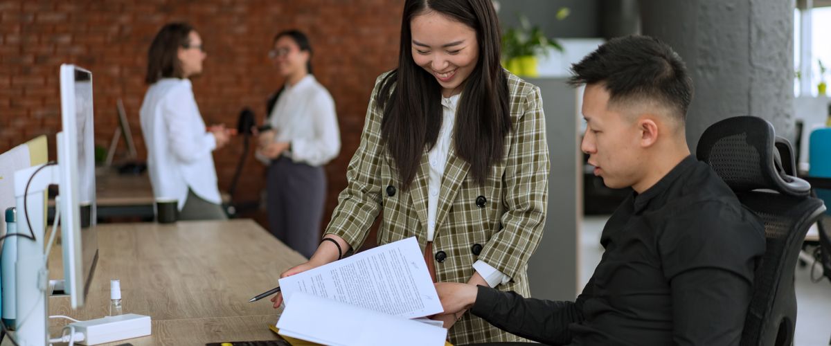 Colleagues reviewing documents at an office desk